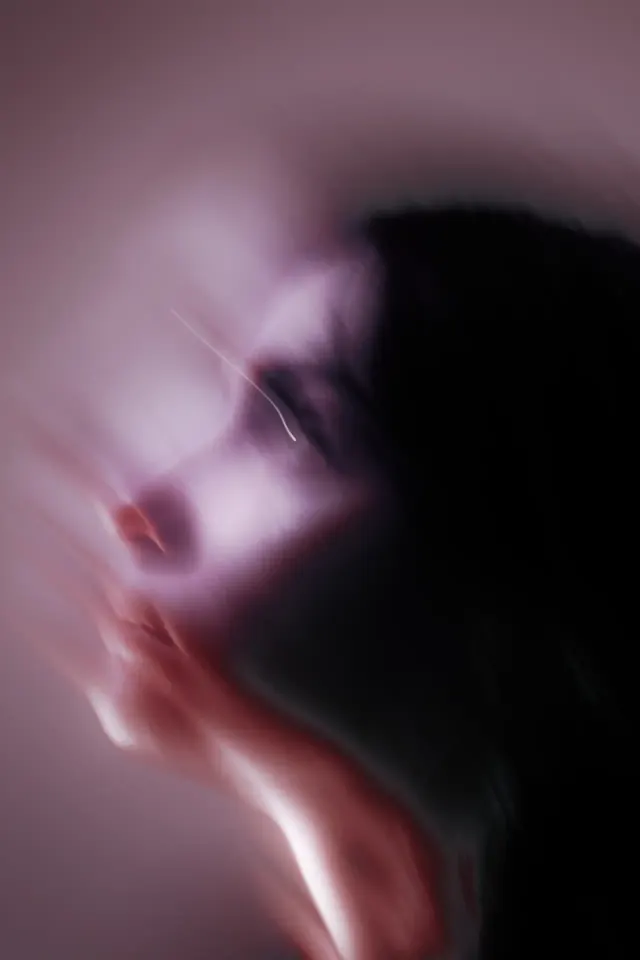 Motion-blurred portrait in magenta light