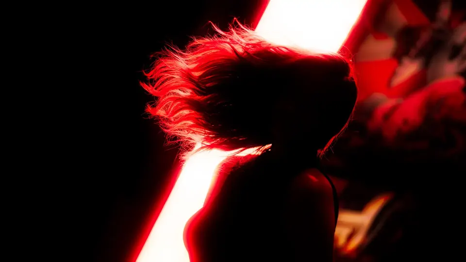 Figure with flying hair lit by red light