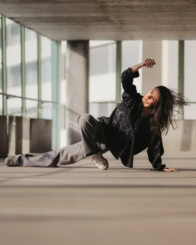 Dancer in a low pose in a concrete industrial hall