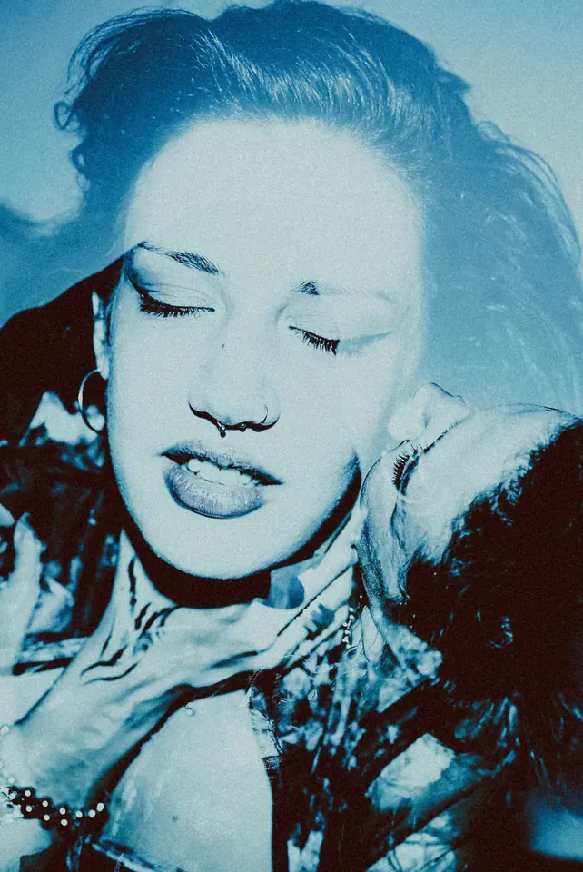 Close-up of a woman with closed eyes, cyan tones