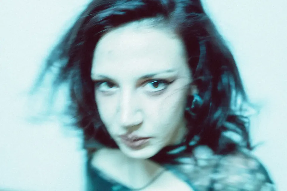 Blurred close-up portrait of a woman in cyan tones