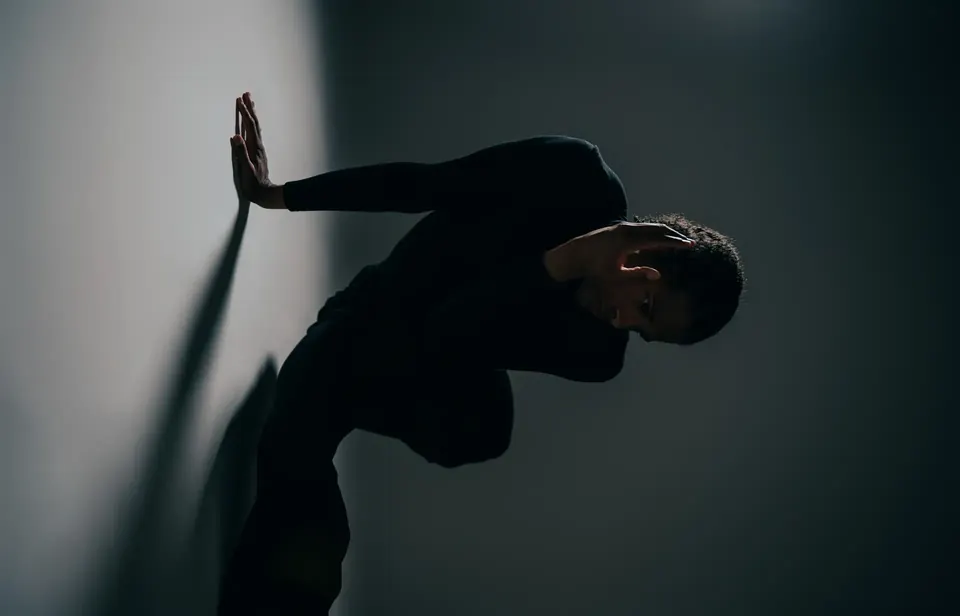 Man leaning against a wall in soft shadow