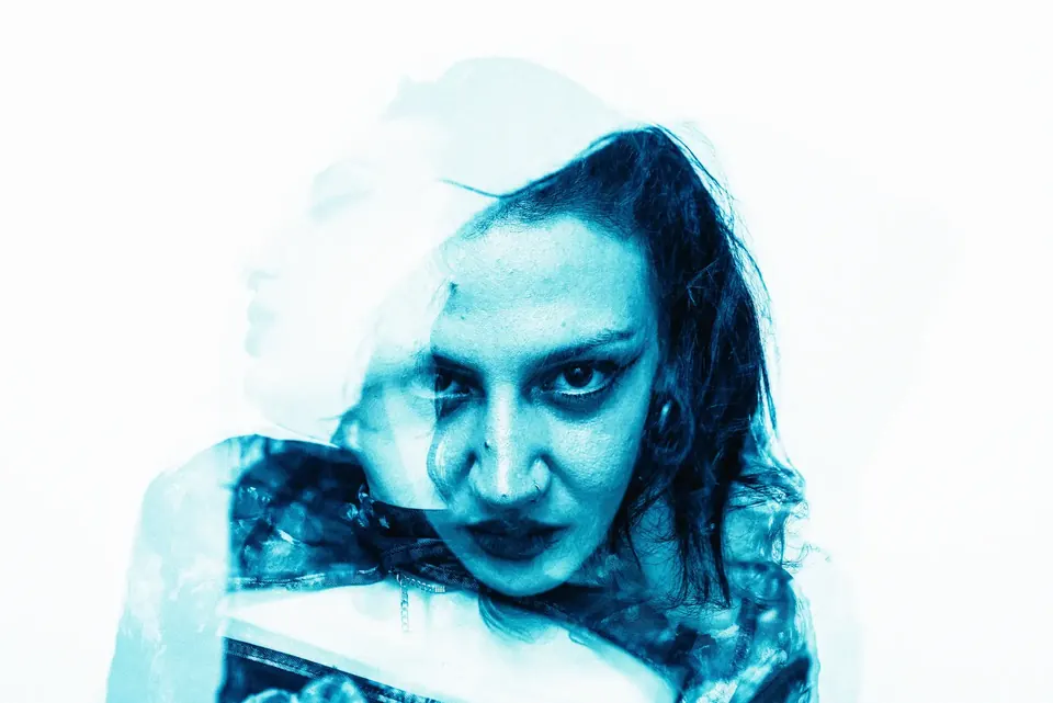 Double-exposure portrait of a woman in cyan tones