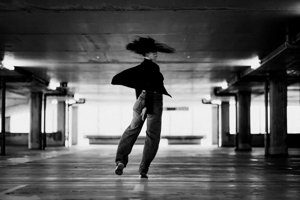 Dancer mid-movement in an empty underground car park, black and white