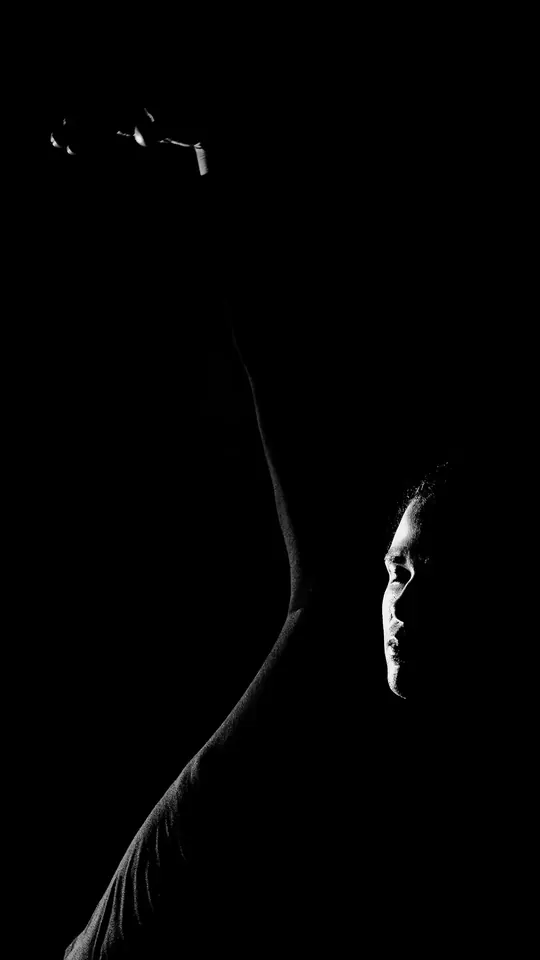 Rim-lit profile emerging from darkness